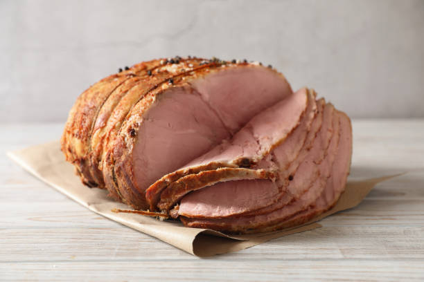 istock Delicious sliced baked ham on white wooden table 1892968838