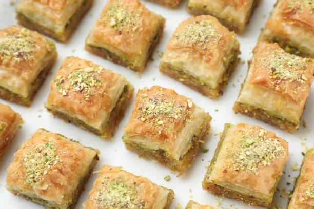 istock Delicious fresh baklava with chopped nuts on white table, closeup. Eastern sweets 1893106182