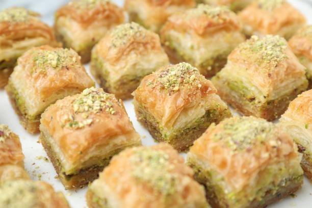 istock Delicious fresh baklava with chopped nuts on white table, closeup. Eastern sweets 1893106184