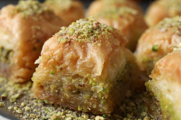 istock Delicious fresh baklava with chopped nuts on plate, closeup. Eastern sweets 1893106192