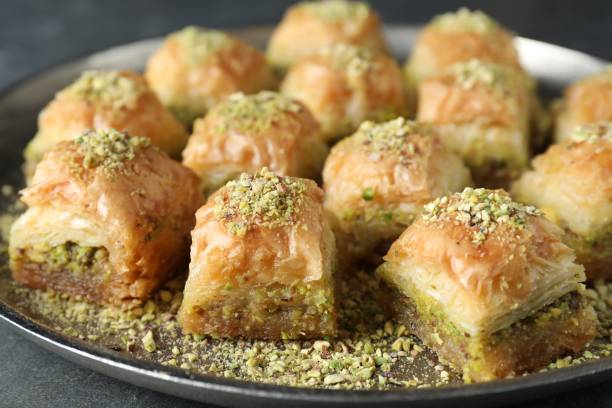 istock Delicious fresh baklava with chopped nuts on grey table, closeup. Eastern sweets 1893107733