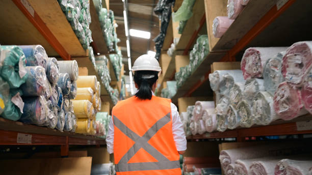Textile/screen printing warehouse. Fabric rolls on pallet, screen printing frames, industry, storage, and artisan production.