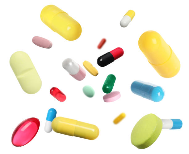 istock Many different colorful pills falling on white background 1893226670