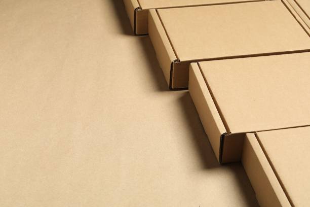 istock Many closed cardboard boxes on light brown background, closeup. Space for text 1893246458