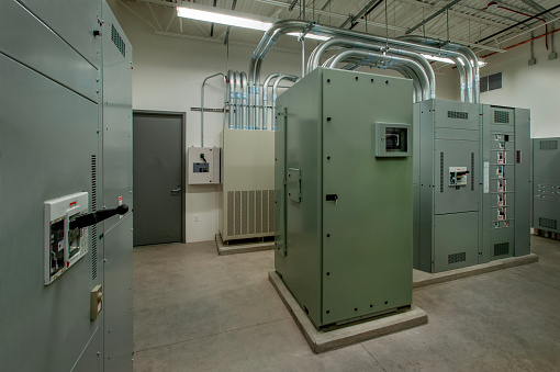 Large electrical room with transformers and control panels.