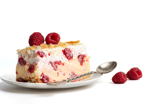 Piece of raspberry summer cake with fresh fruits and vanilla cream. On white background