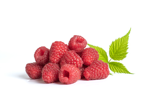 Bunch of red ripe raspberries with leaves isolated on white background