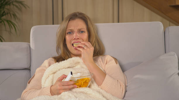 istock CLOSE UP: Young lady becoming upset while watching latest television news report 1893347528