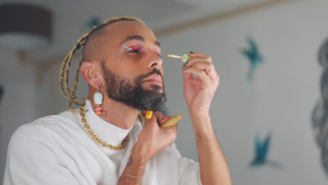 Transgender man applying make-up mascara eyeshadows
