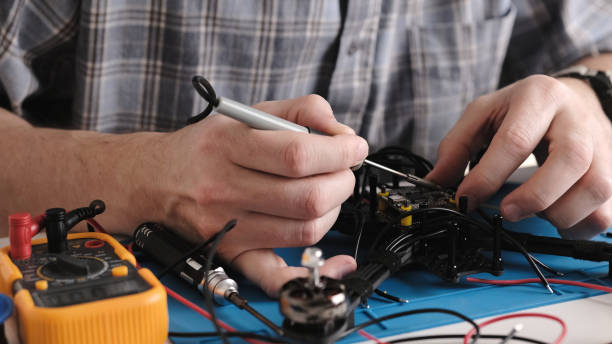 istock Repair Man Soldering Wires And Microchip Board On FPV Hobby Drone 1893501102