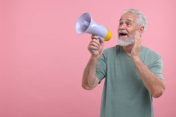 istock Special promotion. Senior man shouting in megaphone on pink background. Space for text 1893514500
