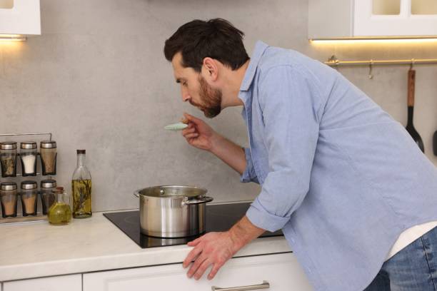 istock Man tasting delicious soup with spoon in kitchen 1893538747