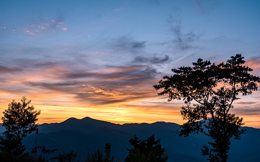 A truly iconic sunset overlooking a breathtaking view in Southern California's Sequoia National Park. The sky is glowing with a rich and vibrant red to orange to blue gradient light and the various mountain ranges disappear into the haze in the distance. No clouds. No people. No distractions.