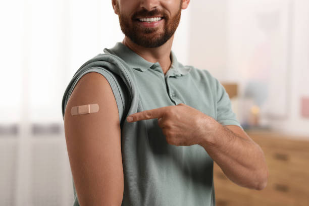 istock Man pointing at sticking plaster after vaccination on his arm at home, closeup 1893574355