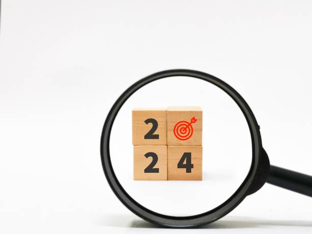 istock Year 2024 target goals searching. Wodeen cubes and magnifier. 1893592775