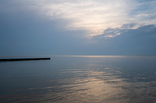 View of wooden breakwaters against the background of the sunset sky and calm on the Baltic Sea, Svetlogorsk, Kaliningrad region, Russia