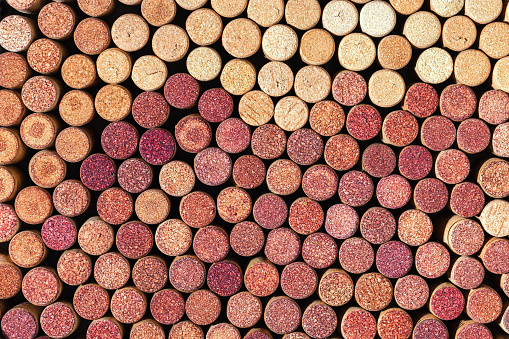 Wine cork background from red and white wine, natural texture used bottle stoppers top view. Closeup wooden corks. Natural textured stoppers colored wallpaper. Bright colorful background wine corks
