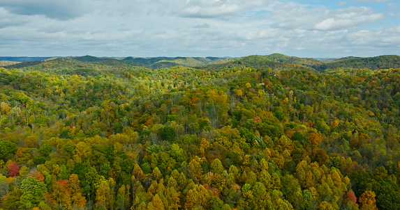 Scenic view of colorful autumn foliage, old stone wall, and rocky summit of Mount Monadnock from country road in Jaffrey, New Hampshire.