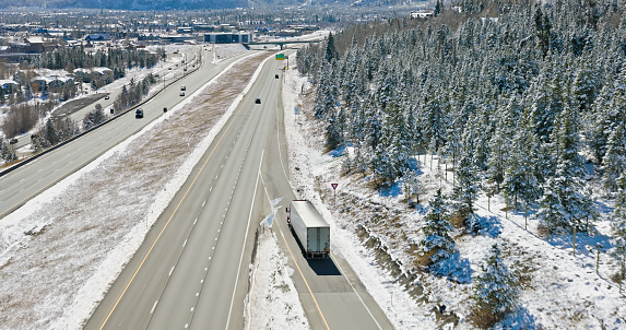 Aerial shot of semi-truck driving through Frisco, a town in Summit County, Colorado on a clear day in Fall after a fall of snow.