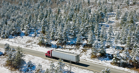 Aerial shot of semi-truck driving through Frisco, a town in Summit County, Colorado on a clear day in Fall after a fall of snow.