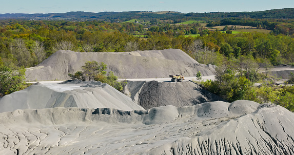 Aerial still of gravel quarry in Liberty Township, a township in Adams County, Pennsylvania, on a slightly cloudy day in Fall.