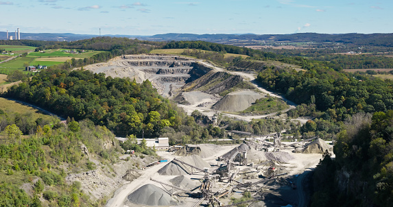 Aerial still of gravel quarry in Liberty Township, a township in Adams County, Pennsylvania, on a slightly cloudy day in Fall.