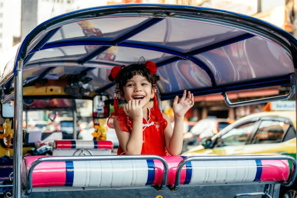 Portrait of a beautiful Chinese girl in traditional Chinese clothing in a tuk tuk on Yaowarat road
