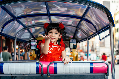 Portrait of a beautiful Chinese girl in traditional Chinese clothing in a tuk tuk on Yaowarat road