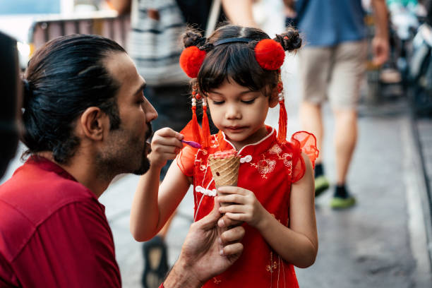 Father and daughter on street with ice cream Lovely little girl with father in traditional Chinese clothing having ice cream cone joyfully on street asian little chinese girls eating ice cream stock pictures, royalty-free photos & images
