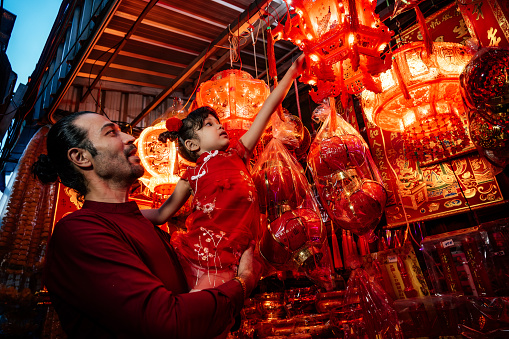 Father and daughter looking at Chinese lantern on street
