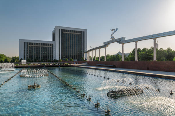 Awesome view of wonderful fountain in Mustaqillik Maydoni (Independence Square) of Tashkent, Uzbekistan. The Ministry of Tourism and Cultural and Storks Monument are visible on blue sky background.
