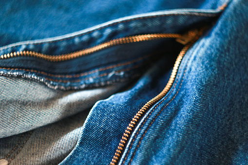 selective focus of blue jeans and gold zip