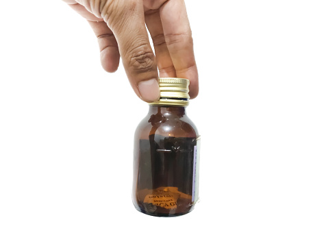 fingers holding or grasping a glass bottle isolated on a white background