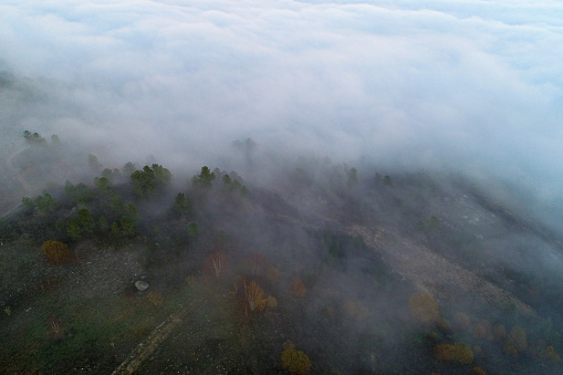 drone aerial view of a mountain in fog