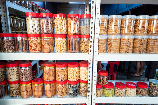 Variety of Chinese New Year cookies in jars place on shelf of retail for sale in Malaysia