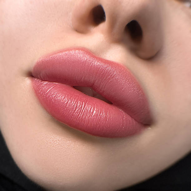 istock permanent womans lips tattoo close up, lipstick effect make up, the lips after a tattoo with a coloring pigment 1894067720