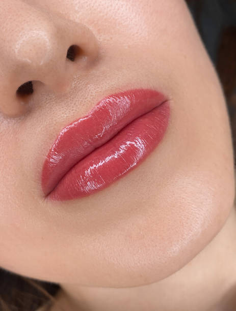 istock permanent womans lips tattoo close up, lipstick effect make up, the lips after a tattoo with a coloring pigment 1894068246