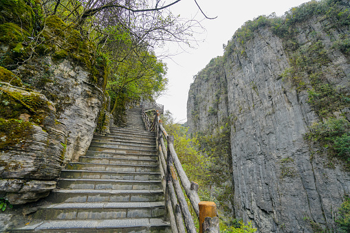 The climbing stone steps are located between two high mountain stone pillars. Enshi Grand Canyon Qixingzhai Scenic Area, Enshi City, Hubei, China.
