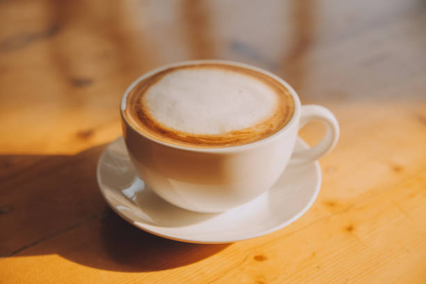 istock Coffee in white cup on wooden table, with spoon. 1894132517