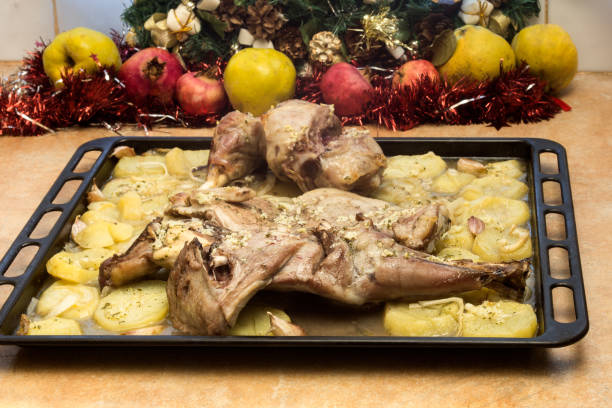 Freshly roasted lamb and potatoes on a baking tray.