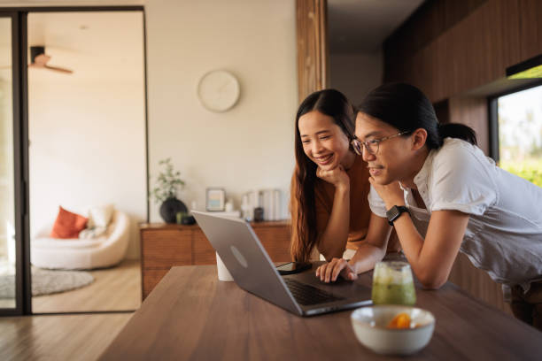 Smiling couple on laptop in the kitchen