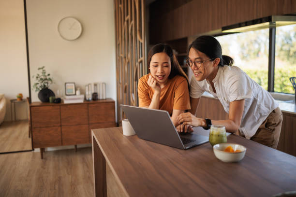 istock Smiling couple on laptop in the kitchen 1894239930