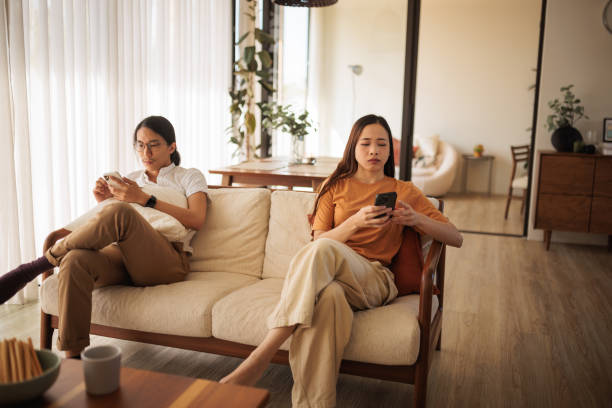 istock Upset couple on sofa with phones 1894241471