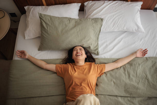 istock Smiling woman throws herself on the bed 1894245602