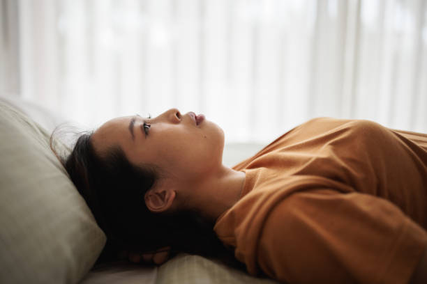 Woman stares pensively at the ceiling