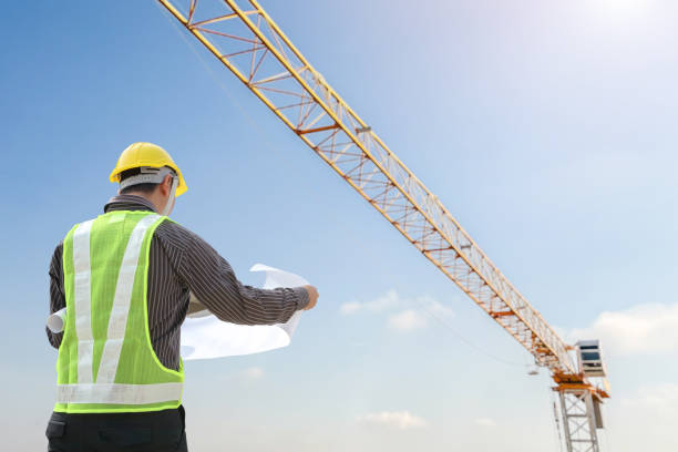 istock construction engineer worker in protective helmet and blueprints paper on hand at building site background 1894259447
