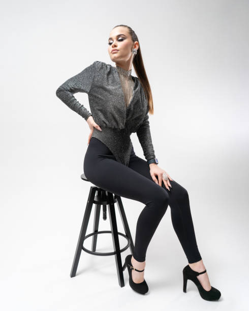 istock An elegant made-up girl model poses in the studio, sitting on a bar stool 1894287175