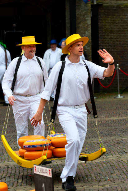 Carriers walking with cheese at a famous Dutch cheese market in Alkmaar, The Netherlands Carriers walking with cheese at a famous Dutch cheese market in Alkmaar, The Netherlands. The event is traditionally perforemed every weekend in the Waagplein square. cheese dutch culture cheese making people stock pictures, royalty-free photos & images