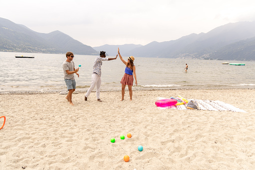 Front view, shot on the action. Two women and a man playing together