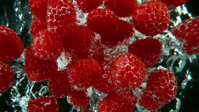 Super Slow Motion Shot of Splashing Fresh Raspberries